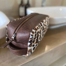 Load image into Gallery viewer, The perfect toiletry bag for those weekend getaways, short holidays, or outdoor adventures. This genuine leather toiletry bag is made from the best quality leopard print material, with a water-resistant lining. The vintage design and leather details create an authentic look and feel while giving you the durability you need in a product like this, which is likely to be used regularly.