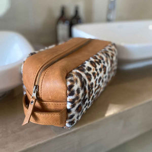 The perfect toiletry bag for those weekend getaways, short holidays, or outdoor adventures. This genuine leather toiletry bag is made from the best quality leopard print material, with a water-resistant lining.  The vintage design and leather details create an authentic look and feel while giving you the durability you need in a product like this, which is likely to be used regularly.