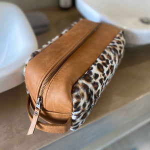 The perfect toiletry bag for those weekend getaways, short holidays, or outdoor adventures. This genuine leather toiletry bag is made from the best quality leopard print material, with a water-resistant lining.  The vintage design and leather details create an authentic look and feel while giving you the durability you need in a product like this, which is likely to be used regularly.